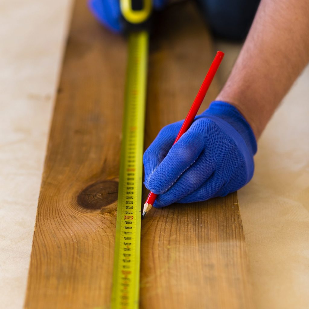 l-homme-utilise-un-ruban-a-mesurer-sur-bois